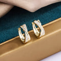 A pair of geometric drop earrings made from copper with zircon detailing and a 14K yellow finish.