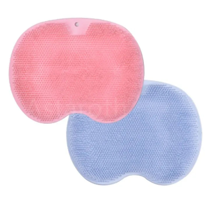 Orange silicone bath massage brush mat with suction cups on a bathroom floor