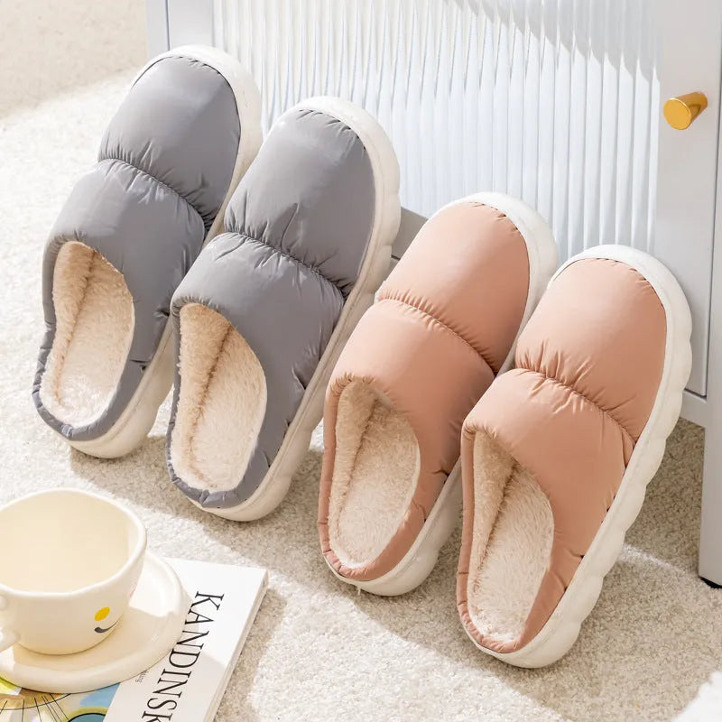 Blue down cotton indoor slippers with thick rubber sole and plush lining, shown on a wooden floor.