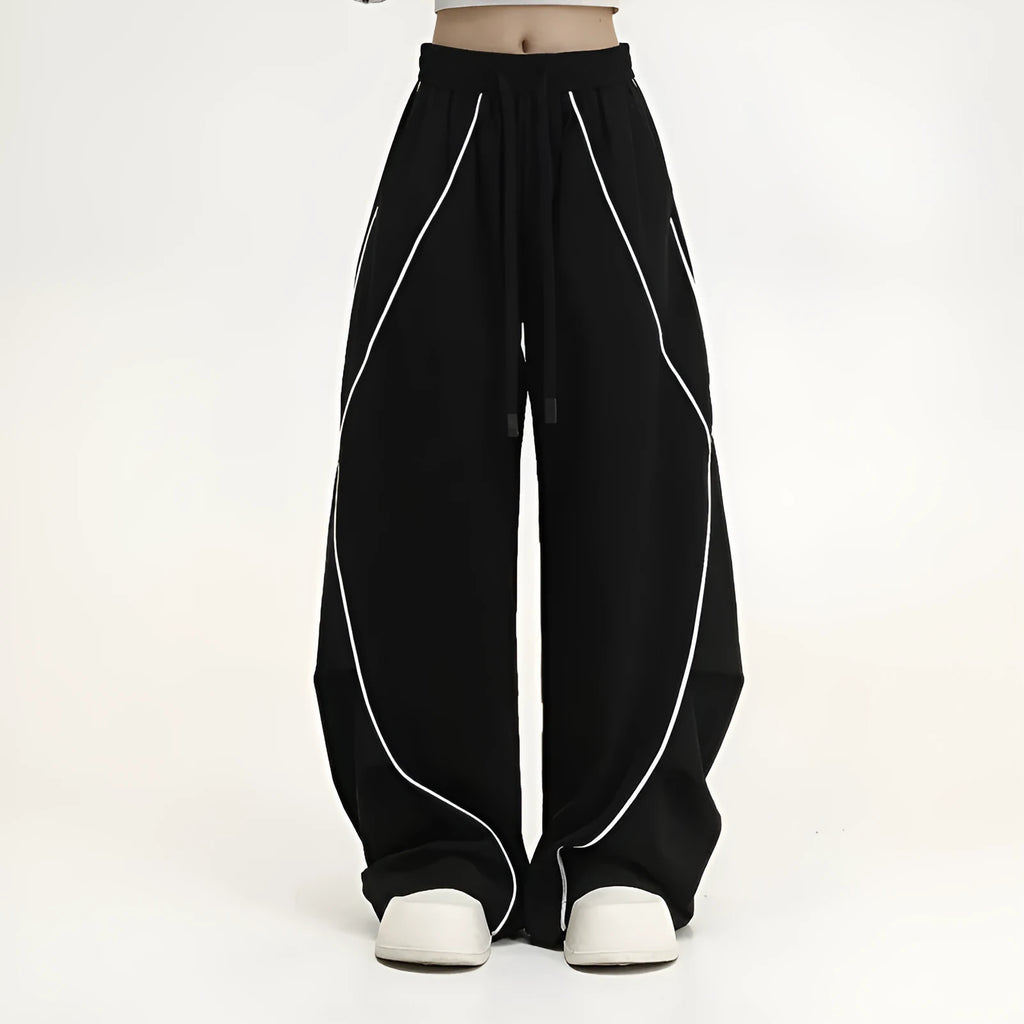 Black and white striped wide-leg hip hop sports trousers with pleats, shown laid flat.