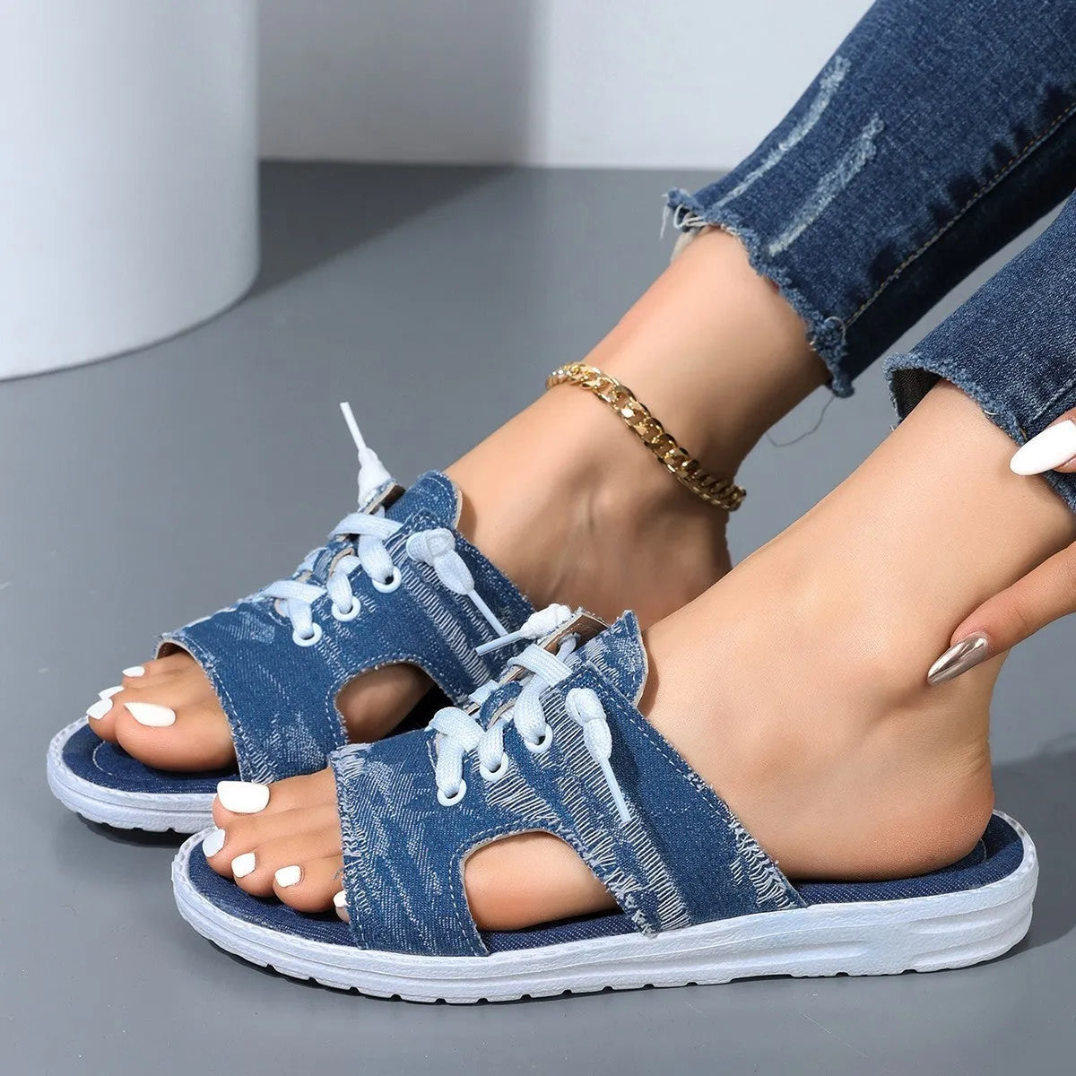 Blue women's flat Roman-style canvas slippers with cloth upper and rubber sole.