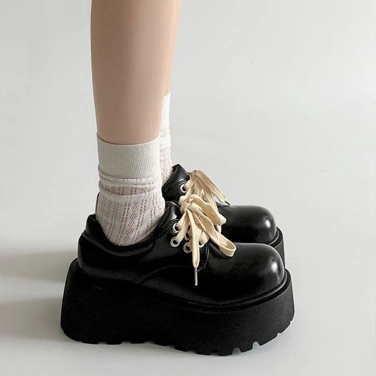 Women's matte black lace-up ankle boots with a thick rubber sole and a chunky heel on a white background.