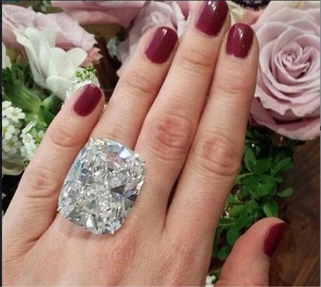 Simple white gold colour women's ring with an inlaid square diamond, showing geometric design.