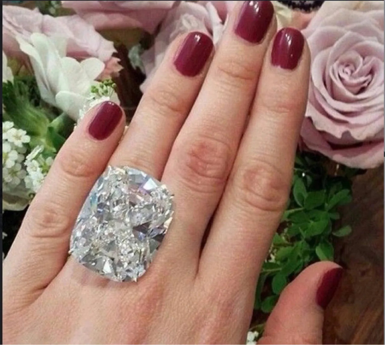 Simple white gold colour women's ring with an inlaid square diamond, showing geometric design.
