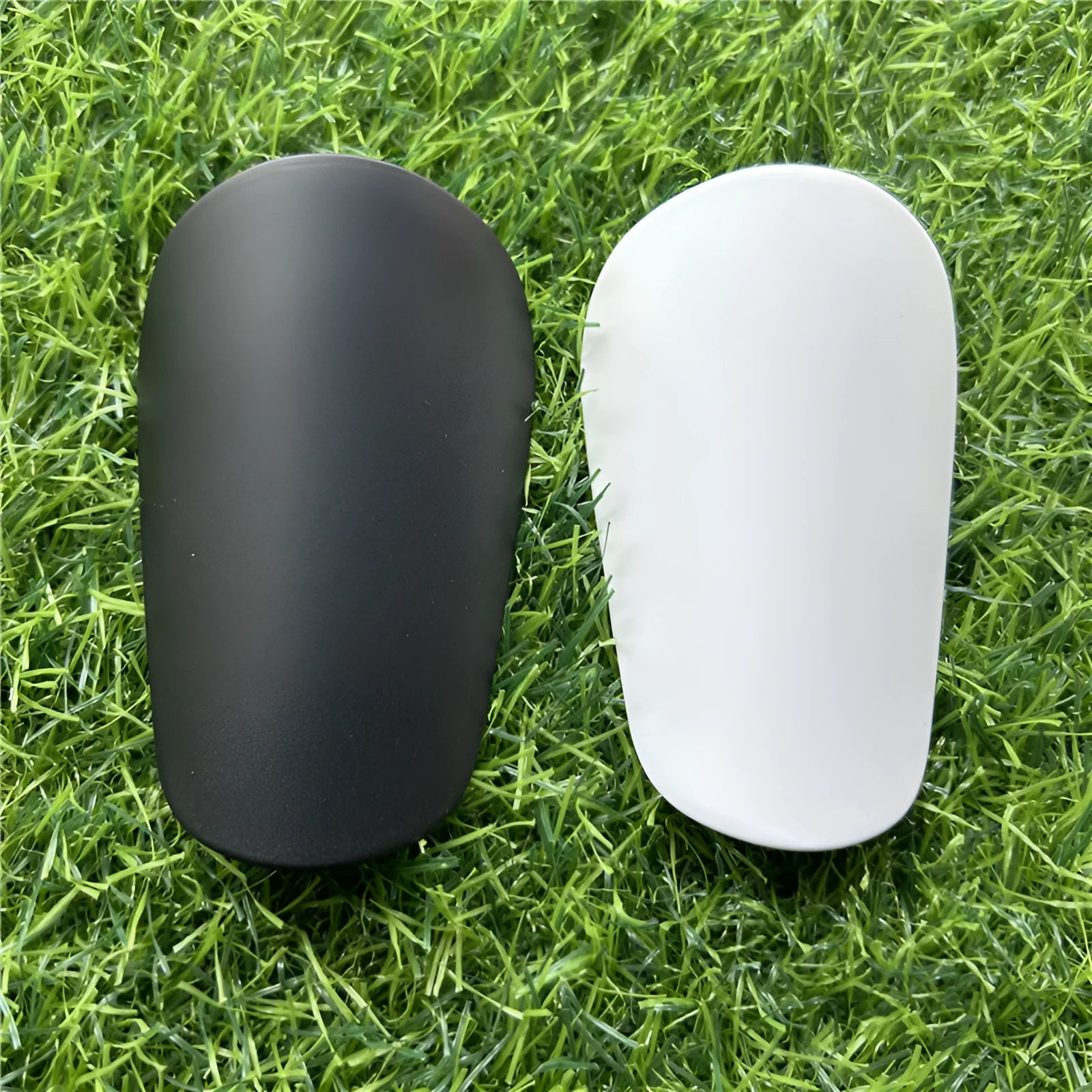 Extra small mini football shin guards in black and white colours measuring 8x5cm