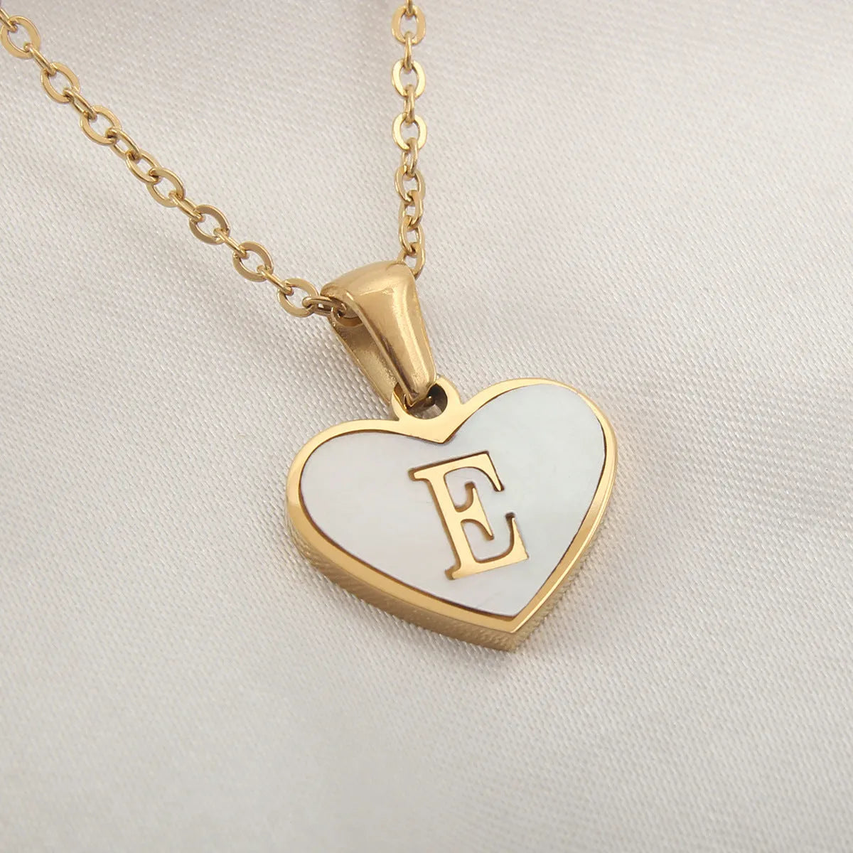 Gold plated heart-shaped white shell pendant personalised initial necklace on a stainless steel chain.
