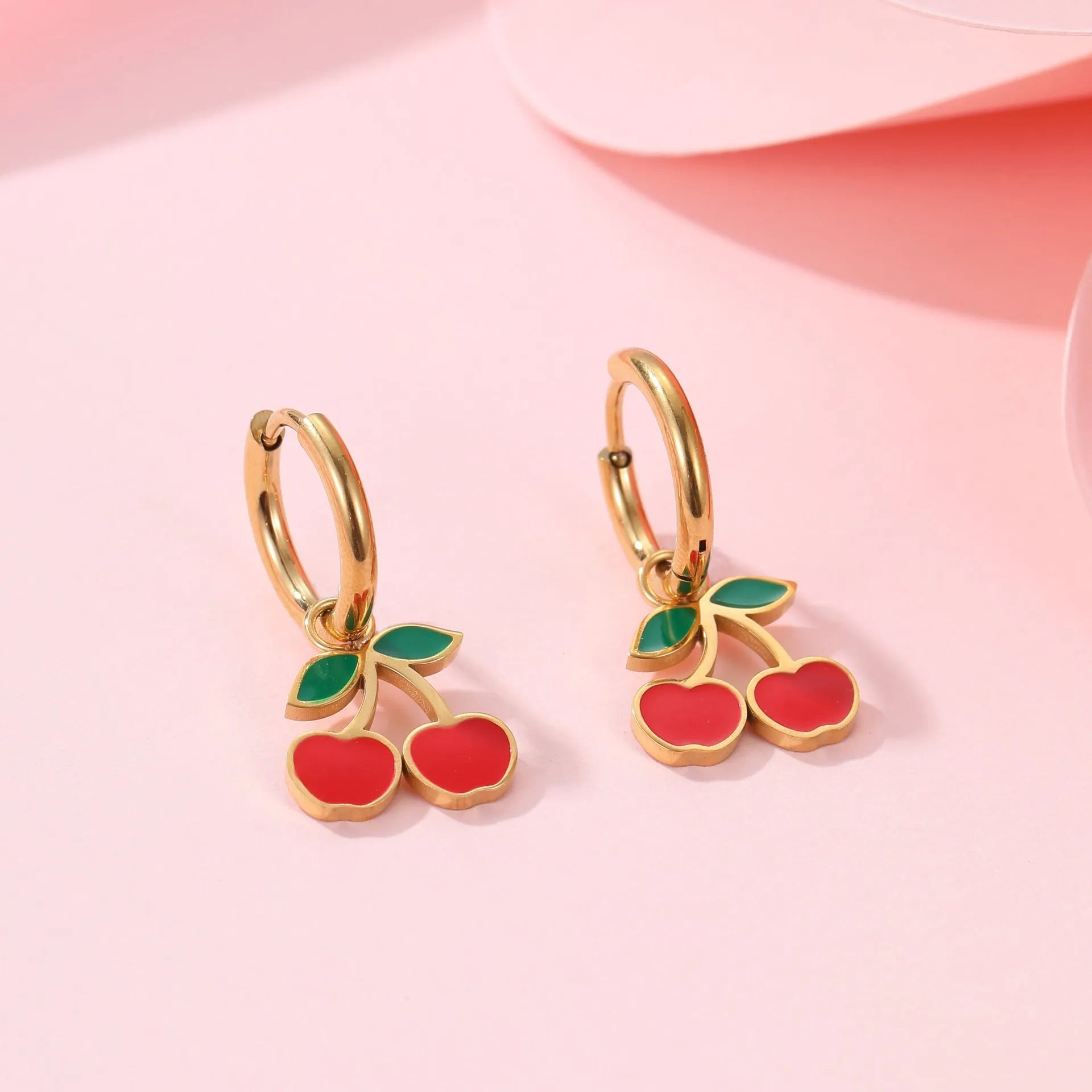 Cherry-themed jewellery set with gold-plated necklace, bracelet, earrings, and ring on stainless steel chains.