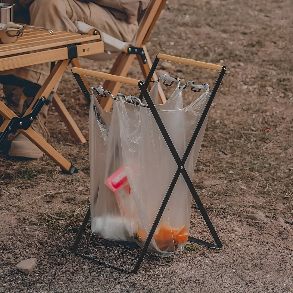 Black folding iron outdoor trash rack with a wooden handle standing upright.