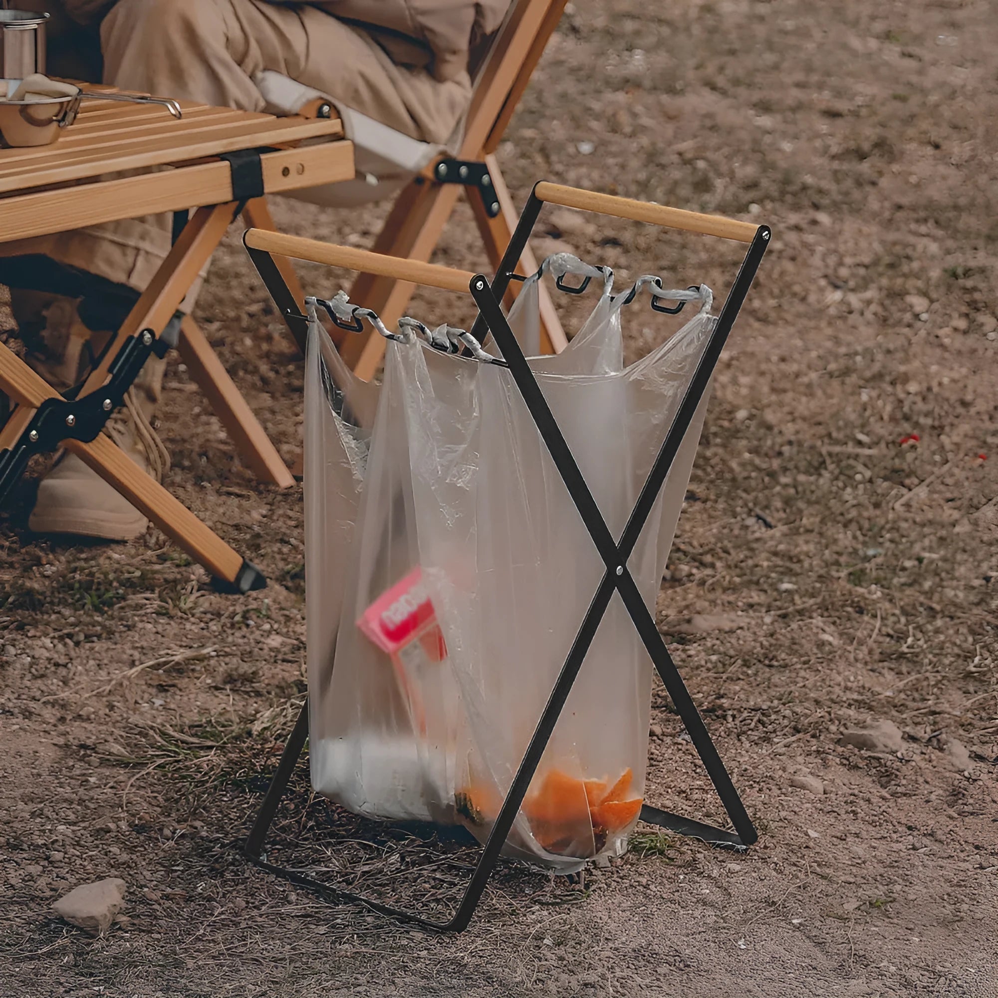 Black folding iron outdoor trash rack with a wooden handle standing upright.