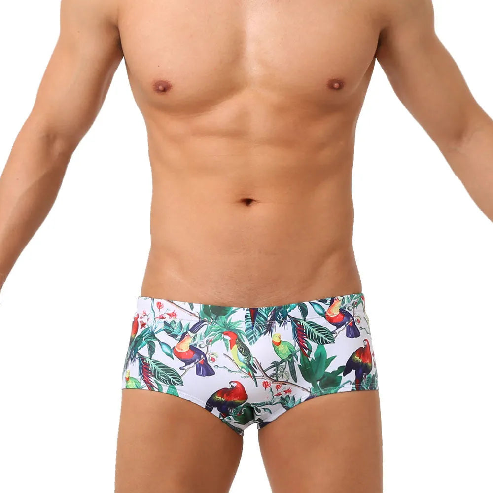 Men's floral and bird print nylon swimming trunks in boxer brief style with cup cover.