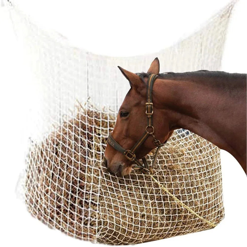 Black woven grid horse feeding bag hanging, filled with hay, for cattle or sheep.