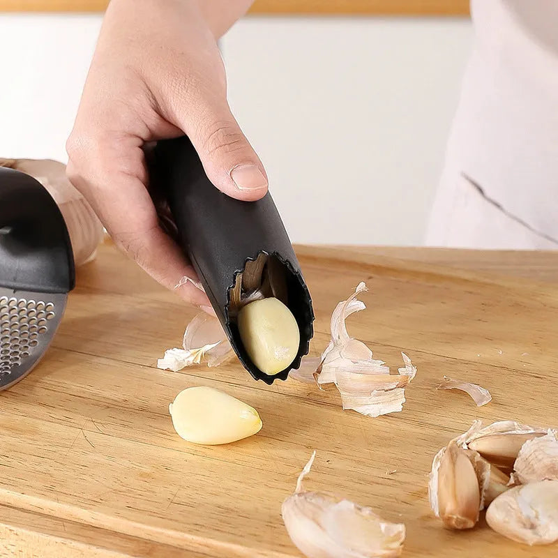 Stainless steel garlic press in green, showing compact 11cm design for crushing garlic.