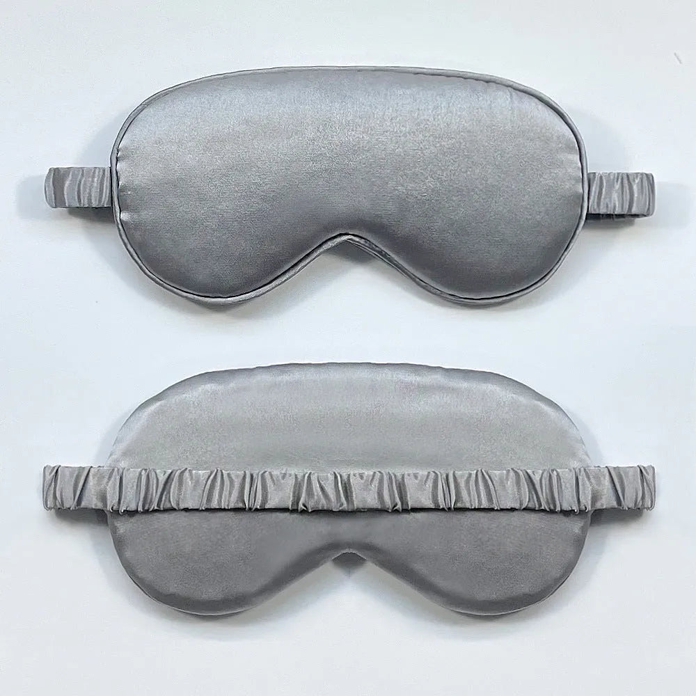 Reversible silk-like sleep eyeshade shown in multiple colour options including sky blue, wine red, and black.