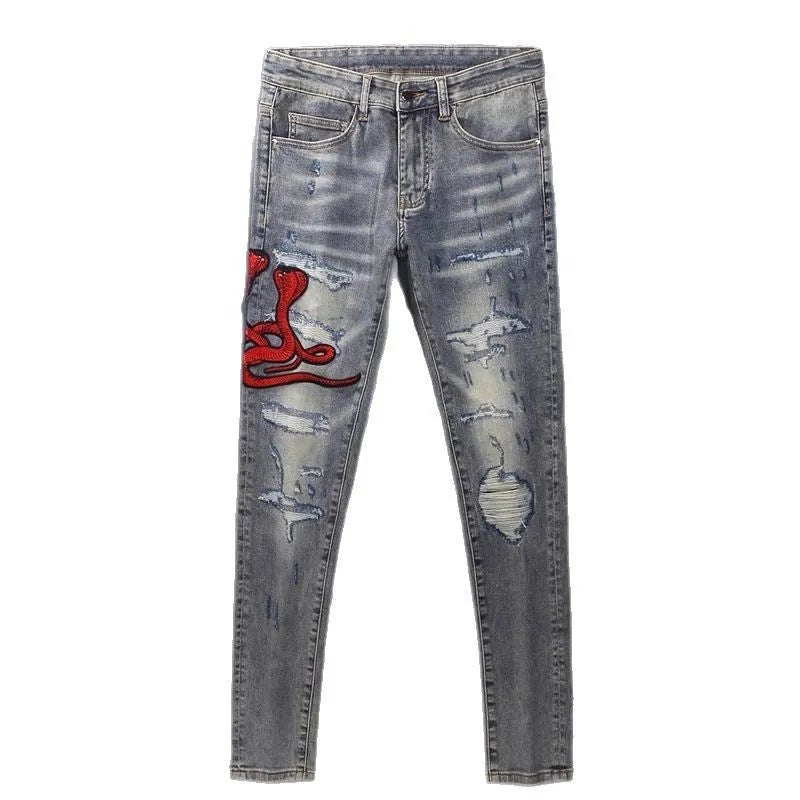 Slim fit jeans with washed-out old colour, distressed holes, and embroidered patches on cotton fabric