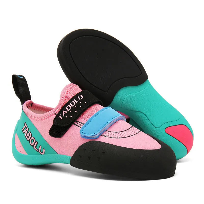 Pair of beginner rock climbing shoes with Velcro strap and black and red rubber outsole.
