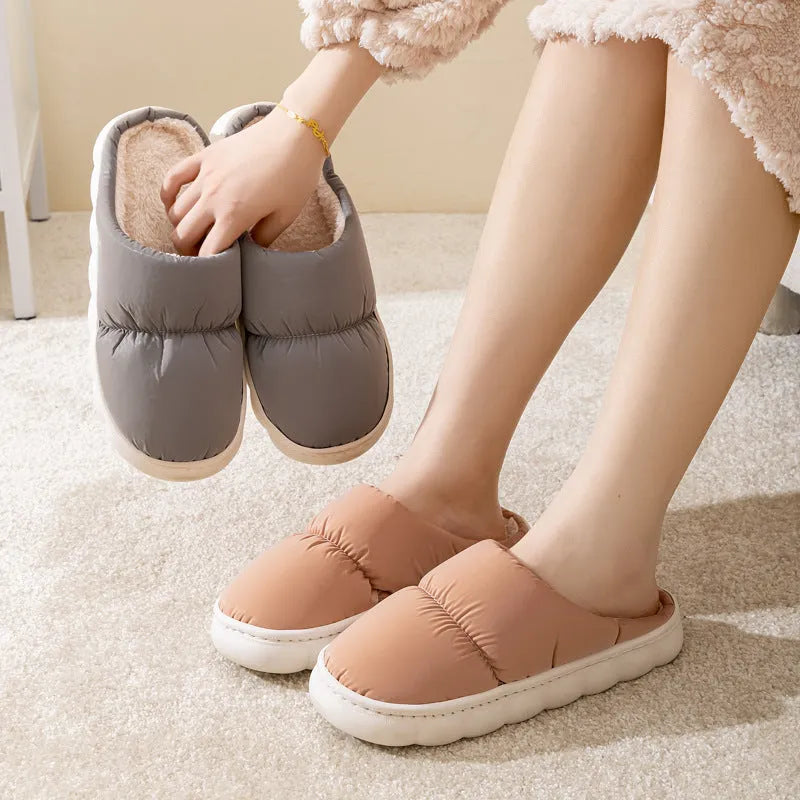 Blue down cotton indoor slippers with thick rubber sole and plush lining, shown on a wooden floor.