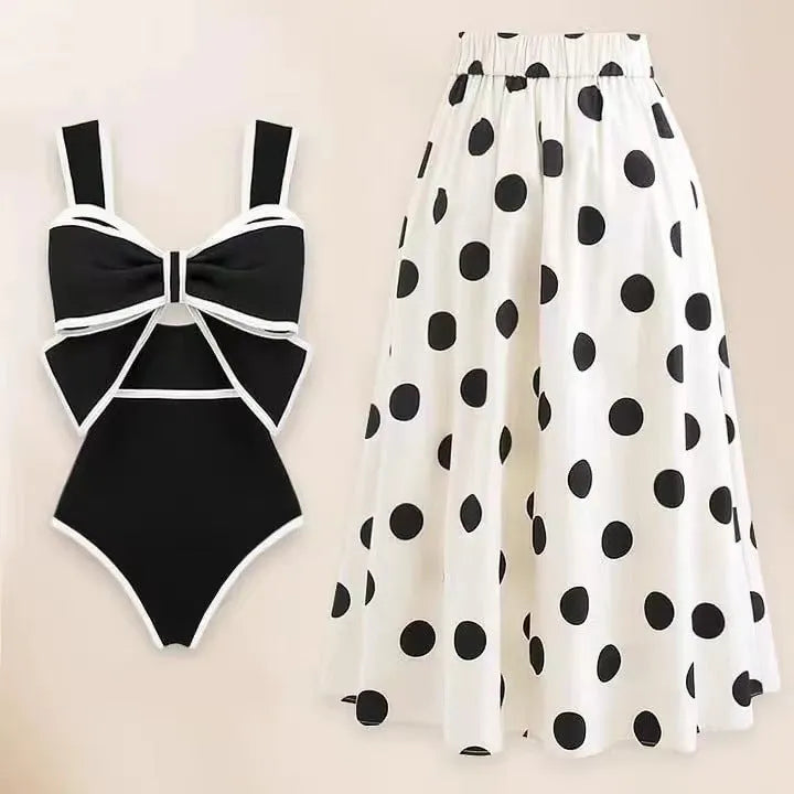Women's black one-piece swimsuit with attached beach dress featuring a round skirt and bow detail.