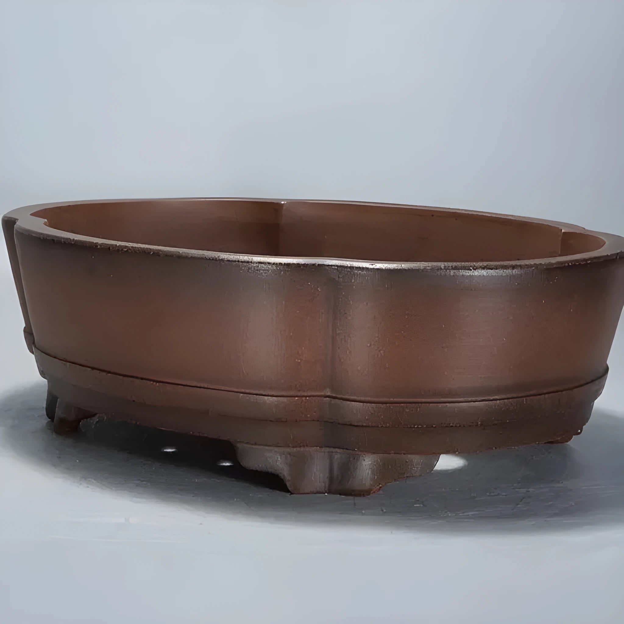 A large, classical-style purple clay flower pot on a wooden floor.