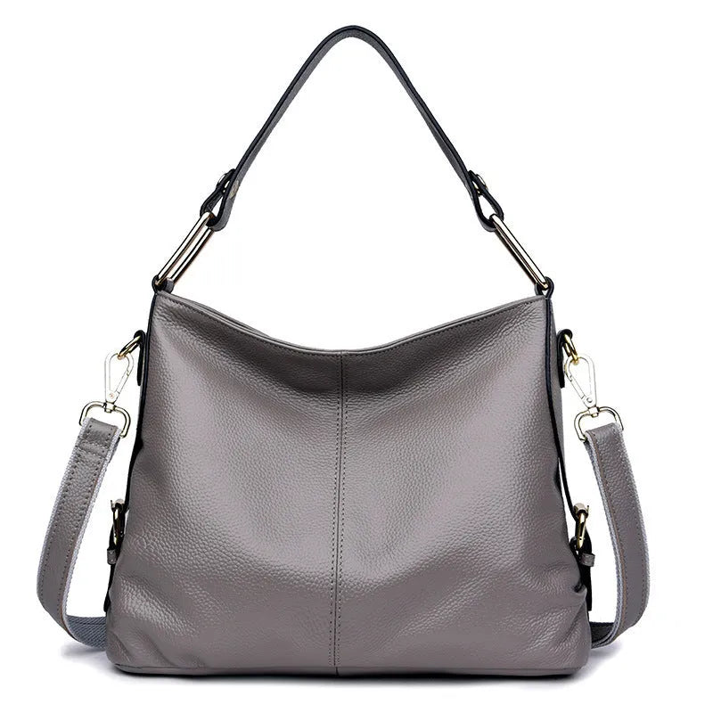 Genuine leather women's crossbody bag in square vertical design, showing internal zipped phone and document pockets.