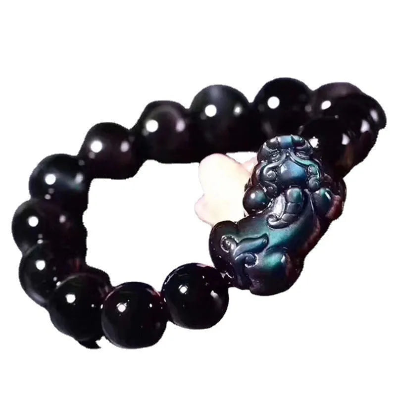 Natural ice colour eye obsidian crystal bracelet on a wrist, showing detail of the stone beads.