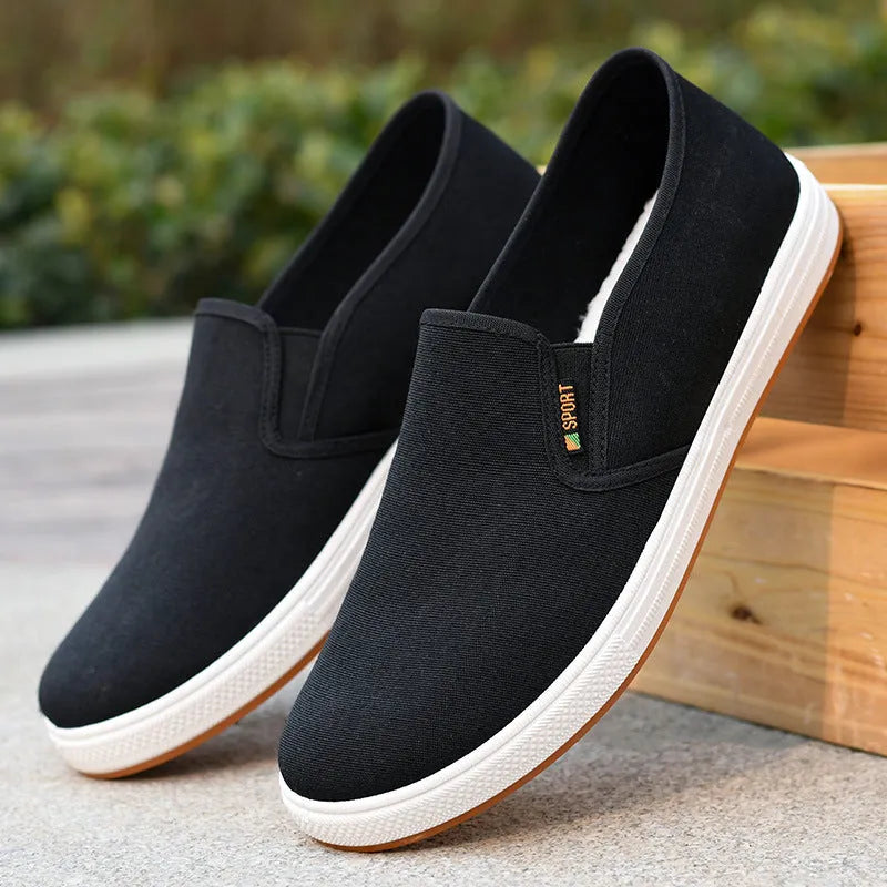 Men's low-top slip-on canvas shoes in black and blue, showing round toe and shallow cut.
