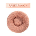 Fluffy donut-shaped dog bed in long plush fabric, shown in a light grey colour with a raised edge.