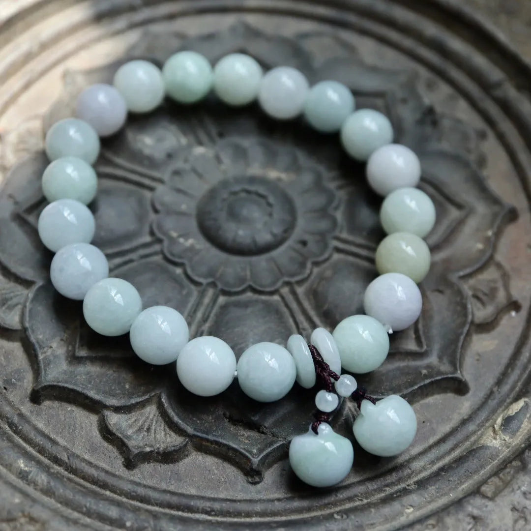 Natural green jade bracelet with hanging geometric charms including an Apple and a Maitreya Buddha pendant.