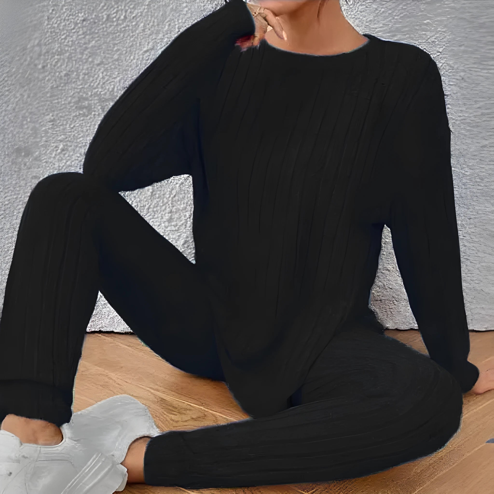 Women's black two-piece lounge set with a sunken stripe pattern on the top and matching trousers.