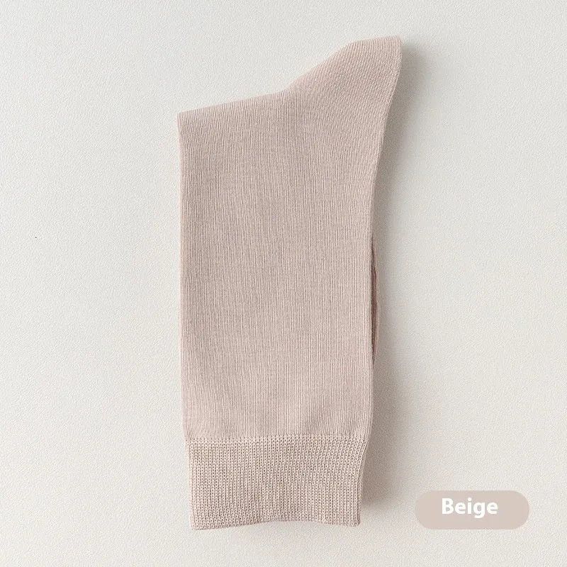 Mid-calf men's socks in solid colours made from combed cotton, shown in a stack.