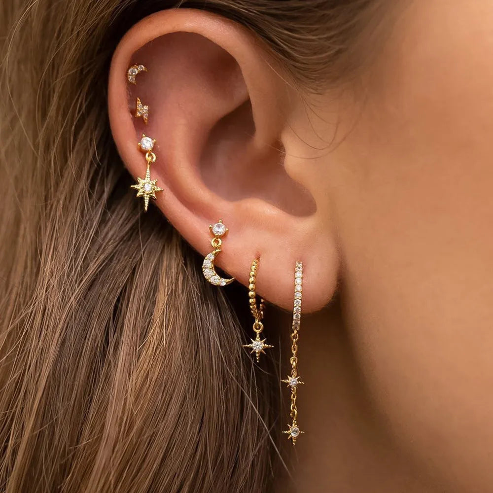 Six pairs of gold electroplated chain tassel earrings with zircon studs on display