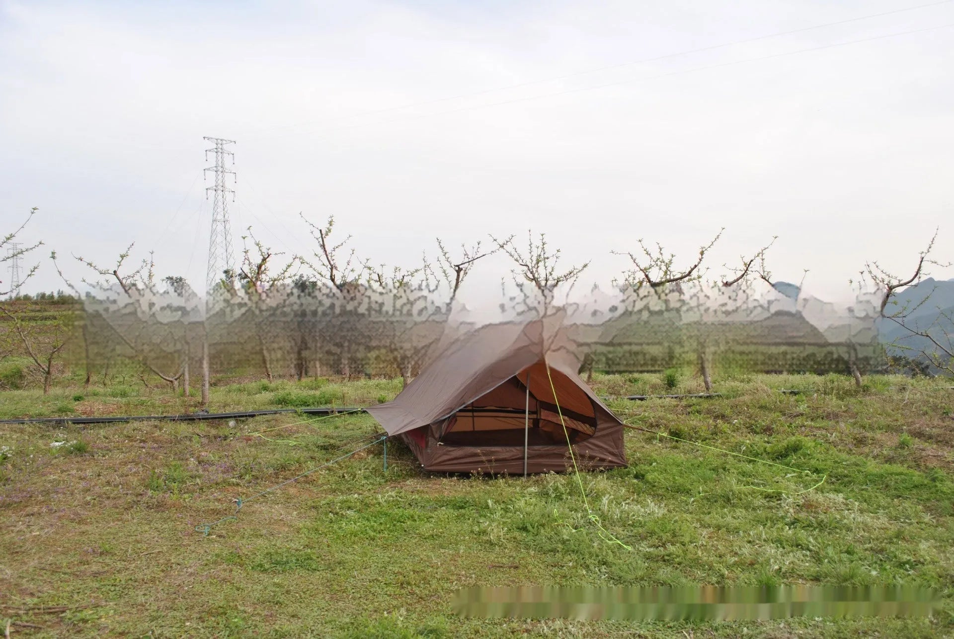 Brown A-line cabin tent pitched with hiking poles as structural support showing spacious interior for 2-3 people