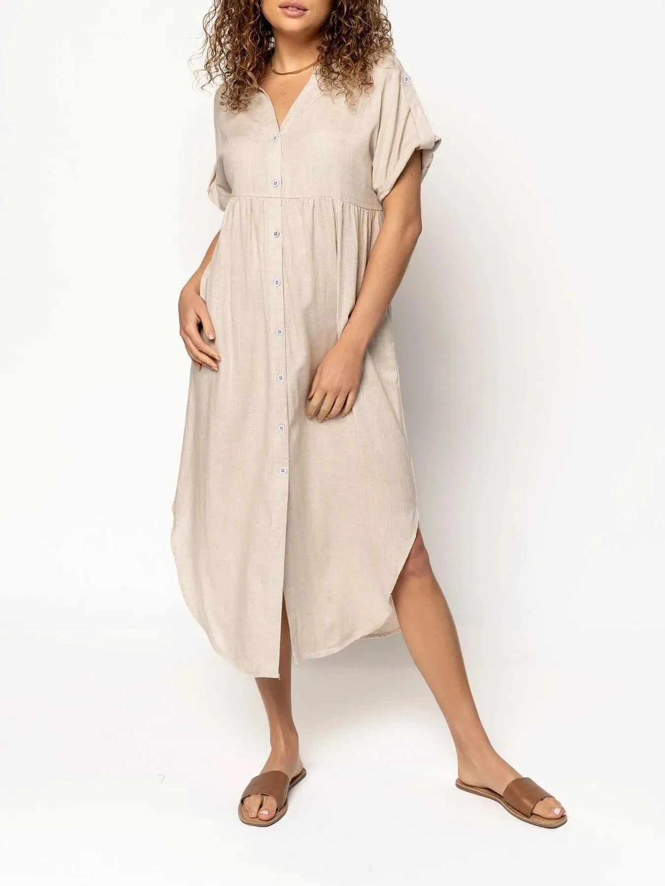 A loose-fitting, solid colour mid-length casual dress with a button-down front and regular sleeves.