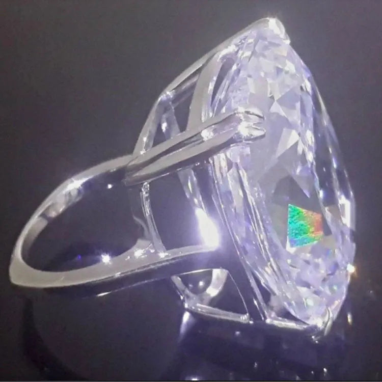 Simple white gold colour women's ring with an inlaid square diamond, showing geometric design.