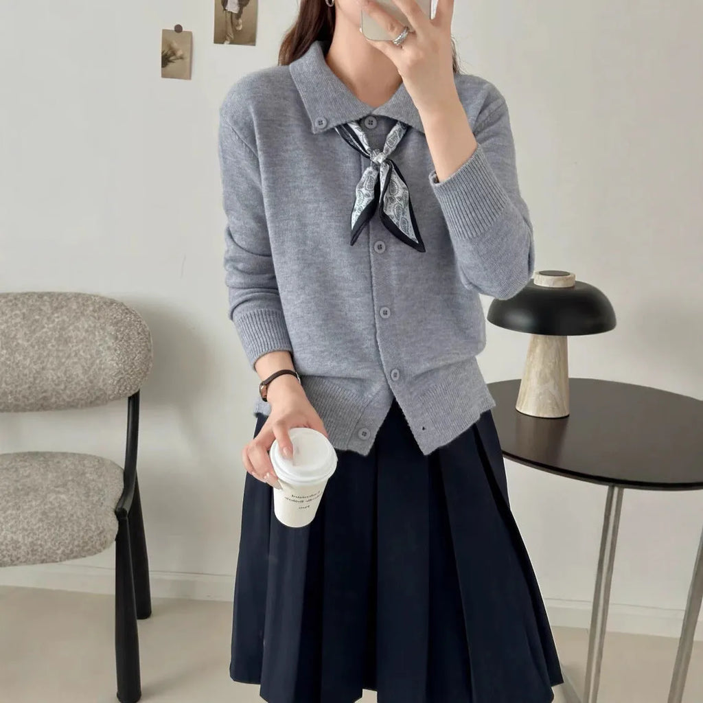 Beige cardigan sweater with attached lapel scarf and long sleeves on a model.