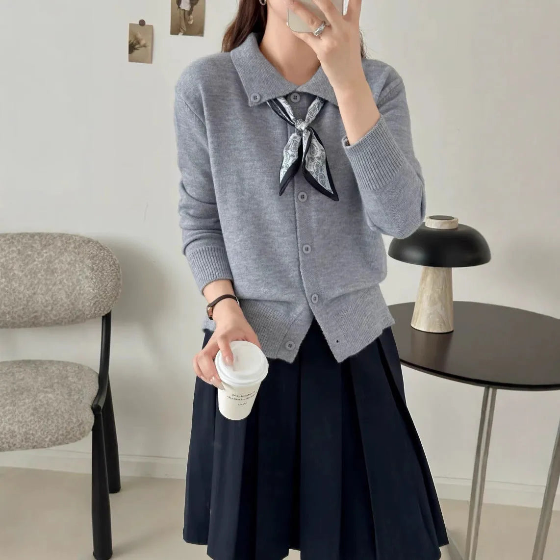 Beige cardigan sweater with attached lapel scarf and long sleeves on a model.