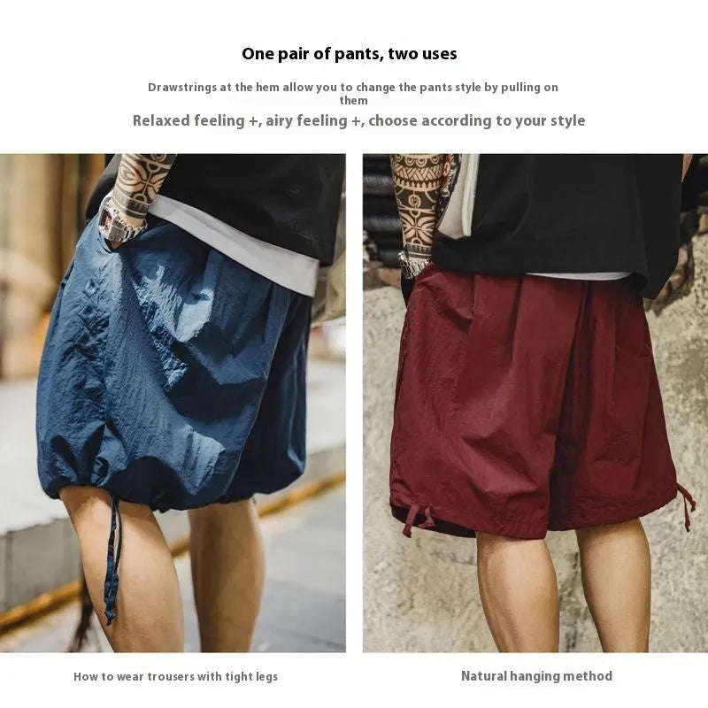 Men's loose fit Prussian blue nylon beach shorts with summer embroidery on a white background.