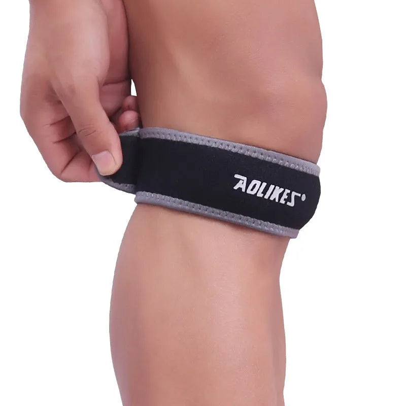 Black and grey patella retinaculum knee protection pad for adult sports use