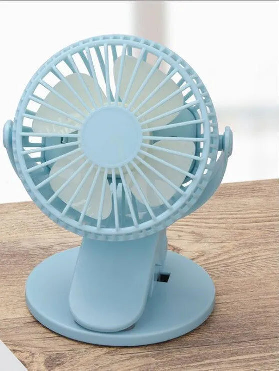 White USB rechargeable mini clip fan with plastic blades attached to a stroller handle.