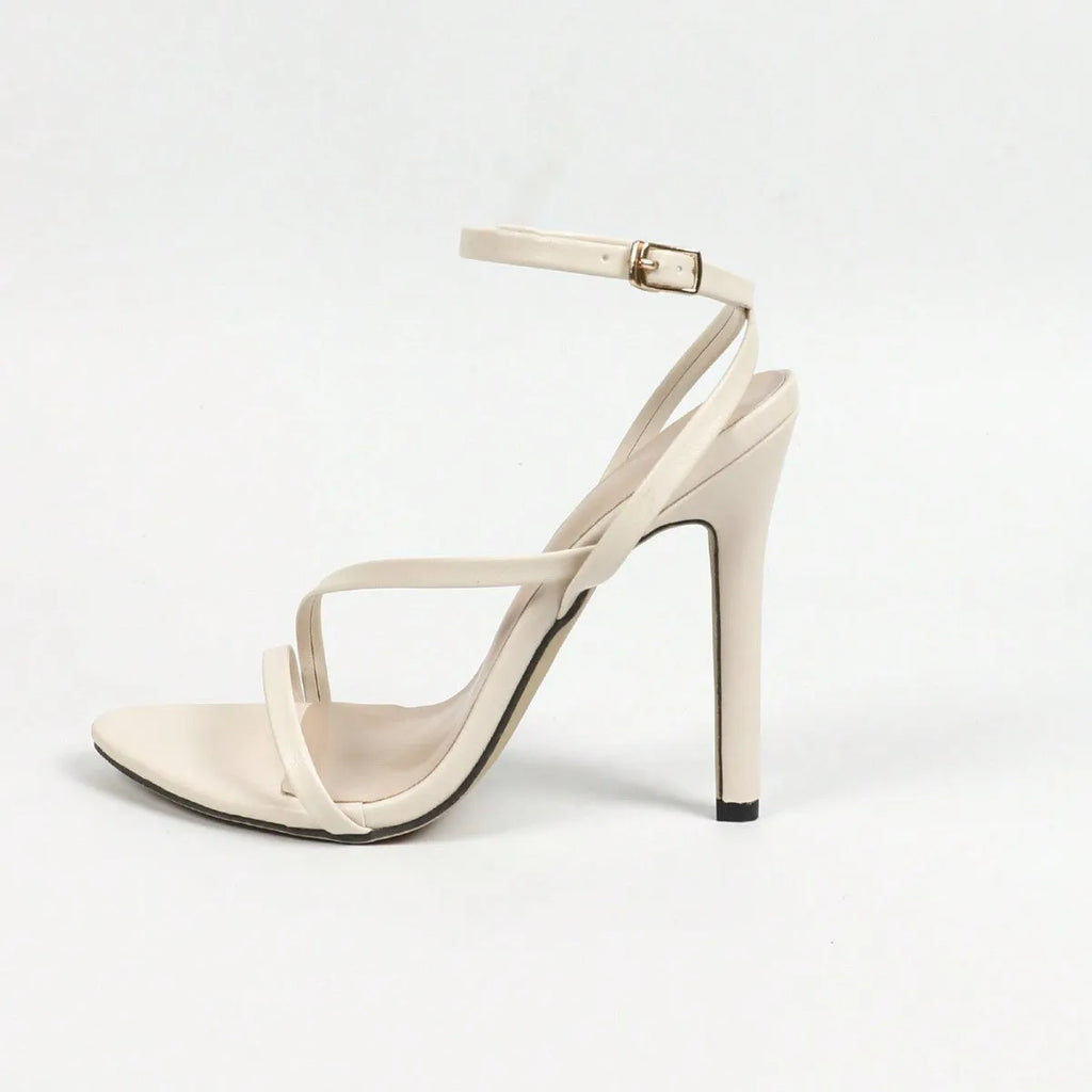 Women's gold high-heel sandals with cross ankle strap and open round toe on a white background