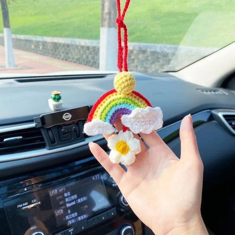 Handmade crocheted avocado flower car pendant in wool with rainbow colours hanging in vehicle