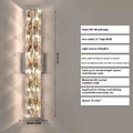 Slim crystal and stainless steel wall lamp with LED light on a wall.