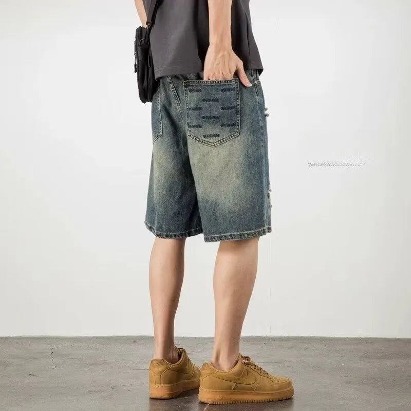Blue denim men's shorts with distressed holes and straight cut design on mannequin