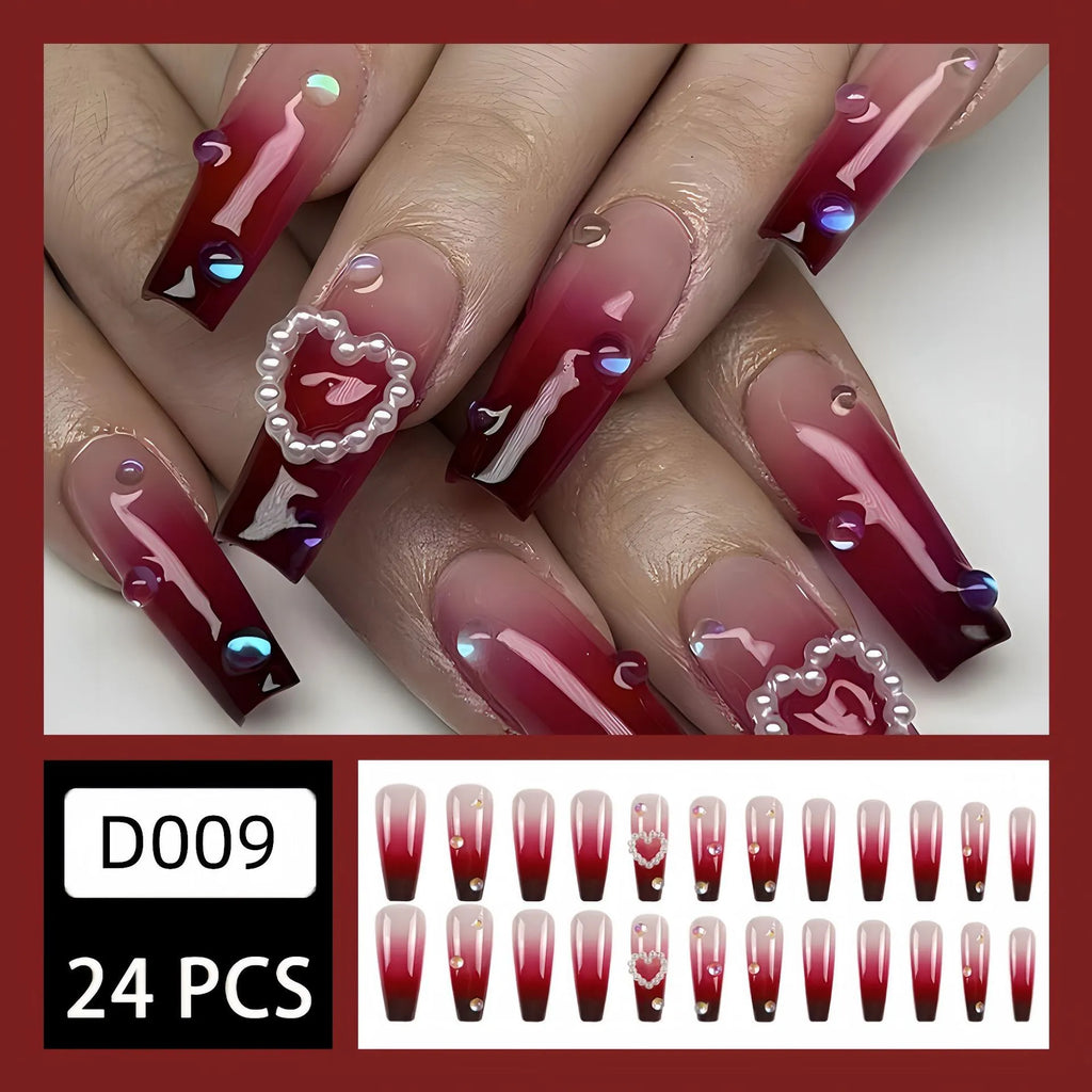 Wine red gradient fake nail tips with pearl heart design in a long ballet style.