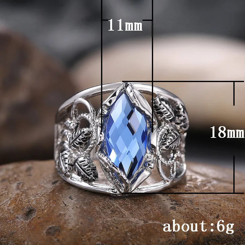Blue crystal inlay on a geometric horse eye-shaped alloy ring for women.