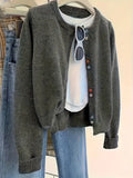 Women's dark grey button-front cardigan sweater with long sleeves on a hanger.