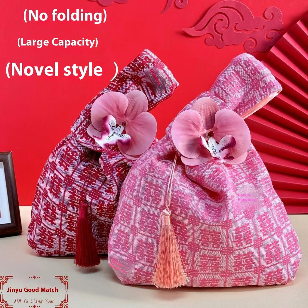 Chinese style gold silk jacquard hand-held cloth gift bag with flower accent in champagne colour on white background