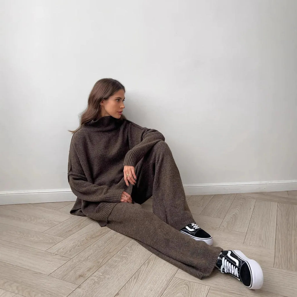 Women's acrylic suit set showing side-slit sweater top with matching trousers in solid colour