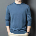 Man wearing a round neck grey wool blend sweater with long sleeves.