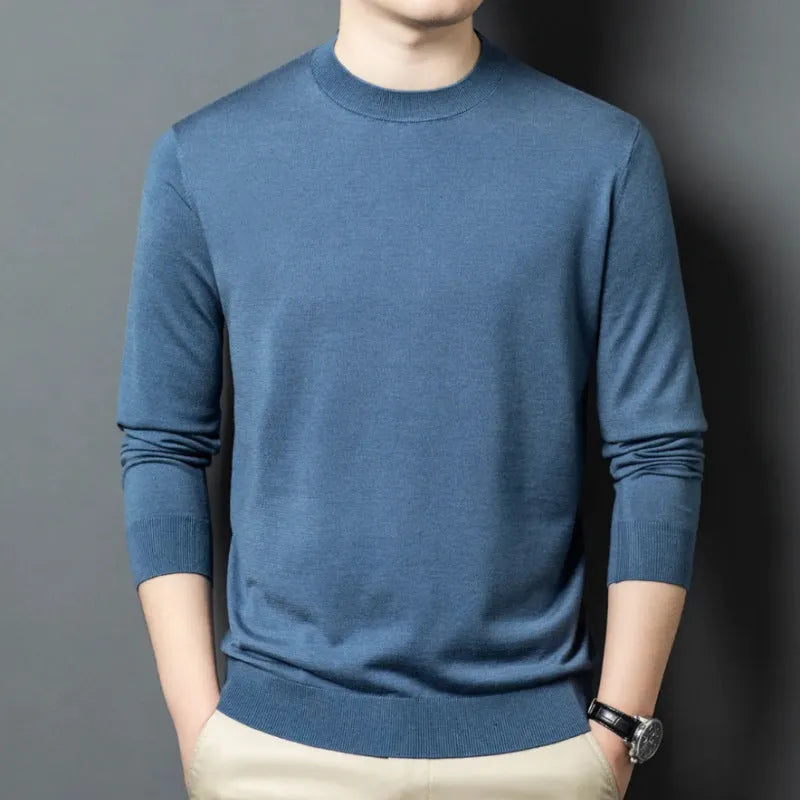 Man wearing a round neck grey wool blend sweater with long sleeves.