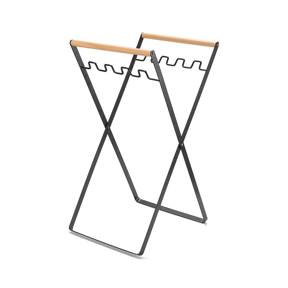 Black folding iron outdoor trash rack with a wooden handle standing upright.